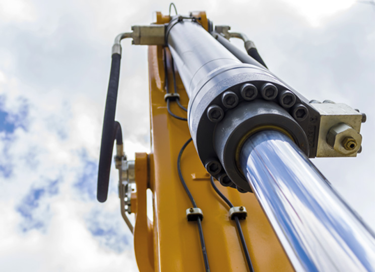 Bild von einem von unten fotografierten Hydraulikzylinder an einer Baumaschine